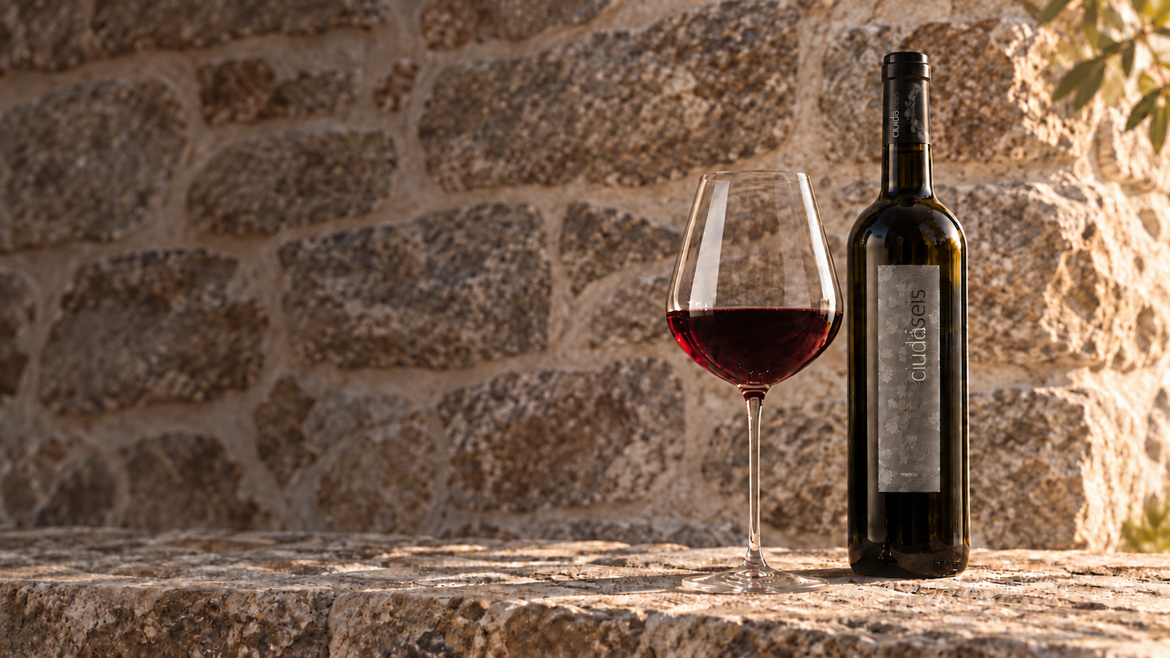 Composición de una botella de Ciudáseis y una copa de vino tinto sobre la piedra de la bodega